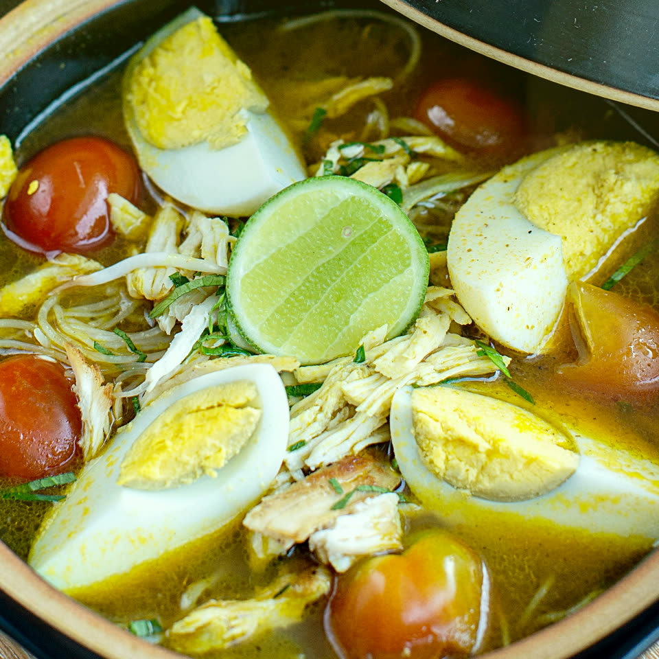 Soto ayam in a clay bowl, with egg