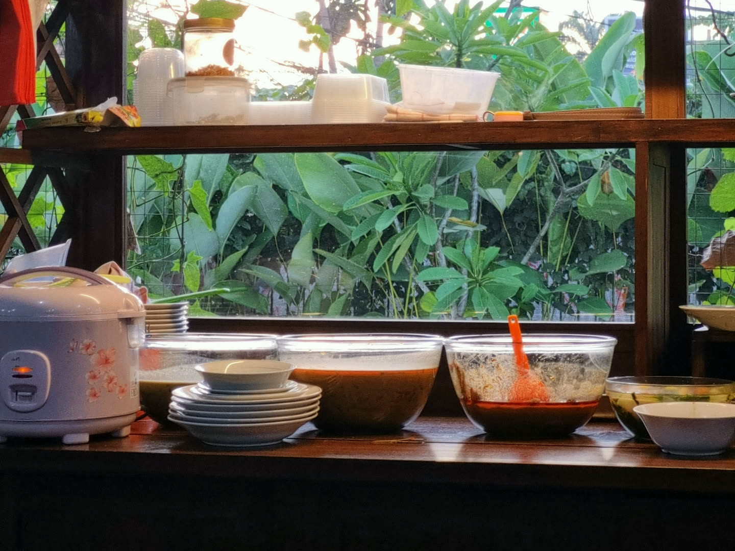 The serving counter inside the warung, with a rice cooker and bowls